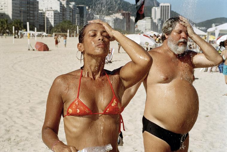 Brazil. Rio de Janeiro. Copacabana Beach. A man and woman take a shower. 2007.